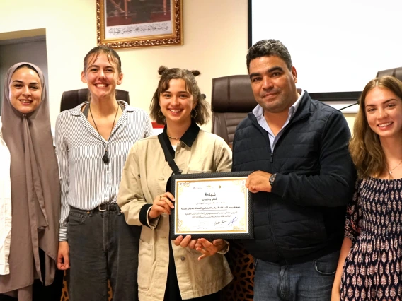 Row of students and certificate in Arabic