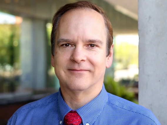 smiling man wearing a red tie and blue shirt