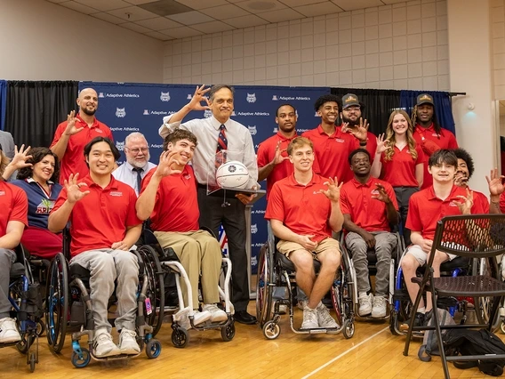 U of A President Suresh Garimella accepts a ceremonial basketball, autographed by members of the national champion men's wheelchair basketball team