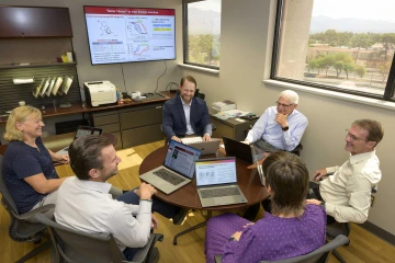Six people sitting around a round table in an office at the University of Arizona
