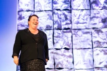 Joellen Russell presents in front of an image of the Franz Josef glacier in the Southern Alps of New Zealand